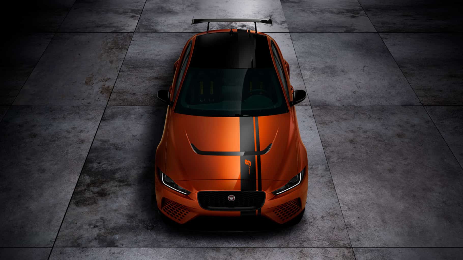 Jaguar XE SV Project 8 in orange with a black strip on grey slabs
